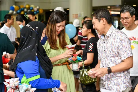 MENYOKONG PENDUDUK RENTAN: Cik Ng Ling Ling bersama Dr Mohamad Maliki Osman melawati reruai sebuah karnival yang diadakan sempena pelancaran Rangkaian Jalan Kayu Prihatin. 
