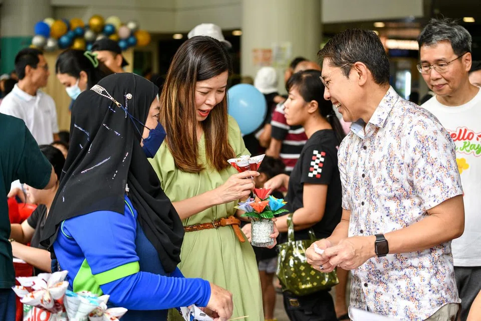 MENYOKONG PENDUDUK RENTAN: Cik Ng Ling Ling bersama Dr Mohamad Maliki Osman melawati reruai sebuah karnival yang diadakan sempena pelancaran Rangkaian Jalan Kayu Prihatin. 