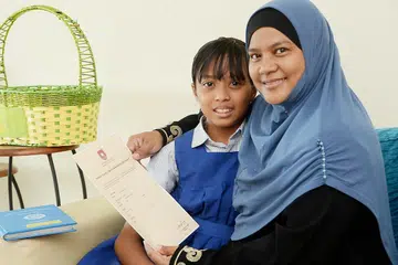 TEKAD MAHU BERJAYA: Walaupun Siti Hawa, bergambar bersama ibunya Cik Mastzainah, mempunyai disleksia, dia berjaya meraih gred B bagi semua mata pelajarannya sekali gus berpeluang memasuki aliran Ekspres. - Foto JOHARI RAHMAT