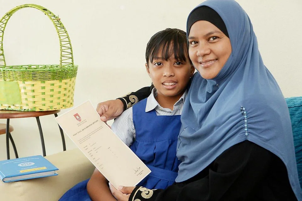 TEKAD MAHU BERJAYA: Walaupun Siti Hawa, bergambar bersama ibunya Cik Mastzainah, mempunyai disleksia, dia berjaya meraih gred B bagi semua mata pelajarannya sekali gus berpeluang memasuki aliran Ekspres. - Foto JOHARI RAHMAT