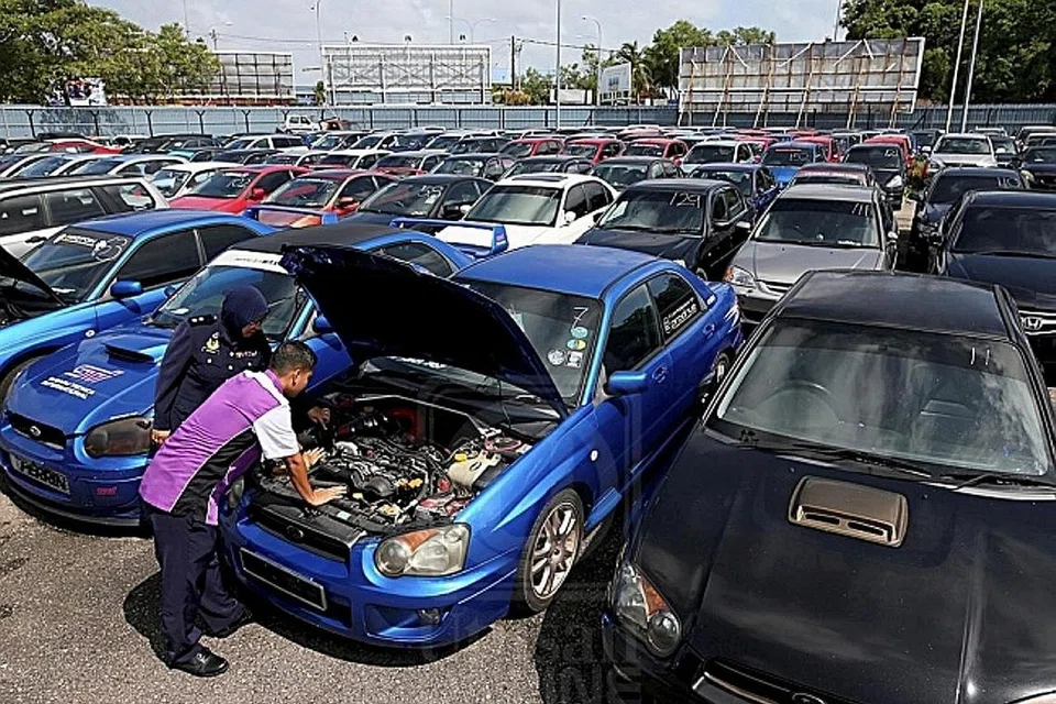 DIPERIKSA: Pegawai Jabatan Pengangkutan Jalan memeriksa kereta klon yang disita di depoh simpanannya Terengganu, baru-baru ini. - Foto UTUSAN MALAYSIA