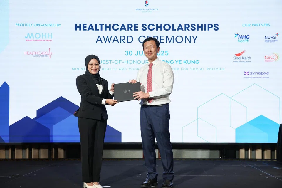 Menteri Kesihatan, Encik Ong Ye Kung (kanan), menyampaikan biasiswa kepada Cik Dina A’tiqah Ahmad Yatim, semasa majlis penyampaian Anugerah Biasiswa MOHH Healthcare pada 30 Julai di Pusat Konvensyen Raffles City.