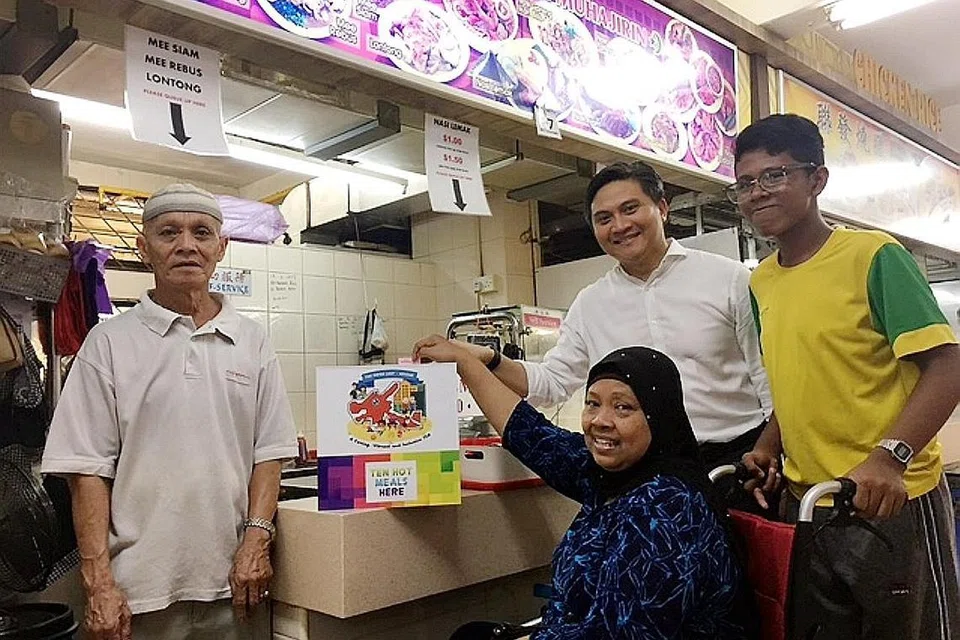 MEMBANGKIT 'SEMANGAT KAMPUNG': (Dari kiri) Encik Mohd Tahir Omar, pemilik kedai makan Muhajirin, merupakan antara pegerai makanan yang menyokong usaha program baru membantu memberi makanan percuma kepada penduduk seperti Cik Rubiah Hussein dan cucunya, Nazarul Faiq (kanan). Bersama mereka ialah AP GRC Bishan-Toa Payoh, Encik Saktiandi Supaat. - Foto FAKHRURADZI ISMAIL