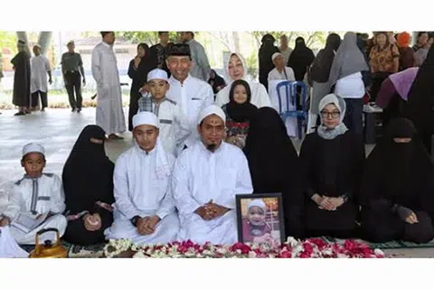 JADI CAKAPAN: Anak Encik Wiranto, Cik Lia Wiranto, yang kehilangan anak ketujuhnya berusia 15 bulan, dilihat dalam gambar memakai niqab hitam, tudung muka penuh. Di sisinya ialah suaminya berpakaian serban putih dan jubah Arab. Gambar pengebumian itu tular di media sosial dan menjadi cakapan. - Foto FACEBOOK WIRANTO