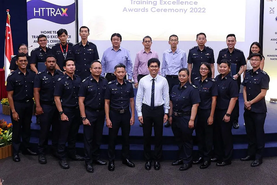 IKTIRAF SUMBANGAN: Menteri Negara (Ehwal Dalam Negeri merangkap Pembangunan Negara), Profesor Madya Dr Muhammad Faishal Ibrahim (tengah di barisan atas) bergambar bersama penerima Anugerah Kecemerlangan Latihan Home Team (Trax) di Akademi Home Team petang semalam. - Foto-foto MHA