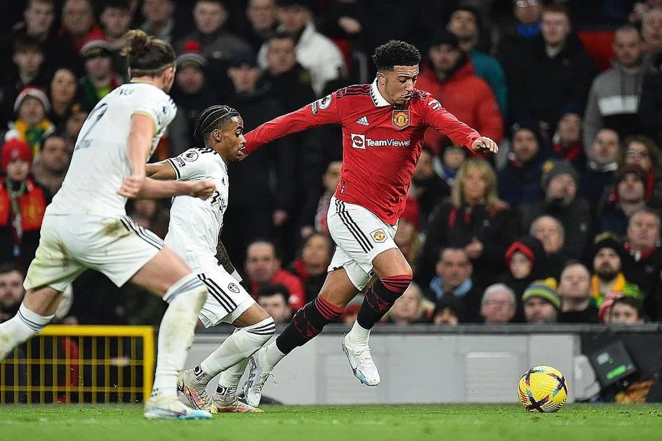 DAPAT SENTUHAN SEMULA: Jadon Sancho (jersi merah) bersaing dengan dua pemain Leeds selepas dimasukkan sebagai pemain gantian. - Foto REUTERS