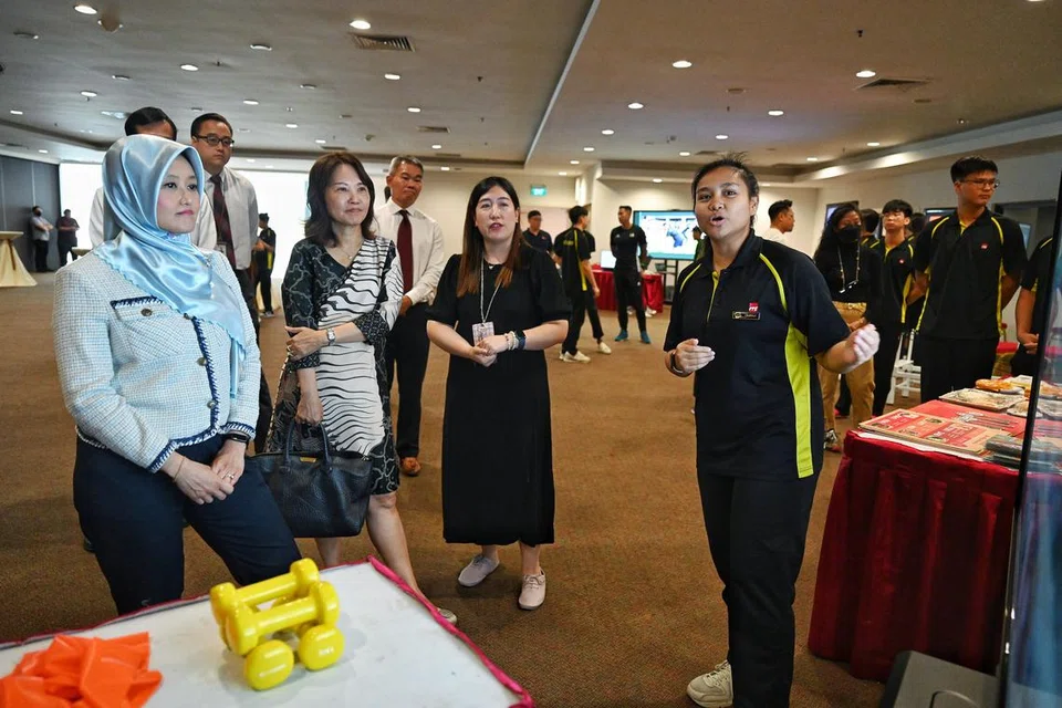 GERAI PAMERAN PELAJAR : Setiausaha Parlimen Kanan (Kesihatan merangkap Undang-Undang), Cik Rahayu Mahzam (kiri) melawat gerai pameran yang diadakan oleh pelajar-pelajar ITE termasuk Cik Adriana Ibrahim (kanan), pelajar peringkat Nitec Lanjutan ITE dalam bidang pengurusan sukan. 