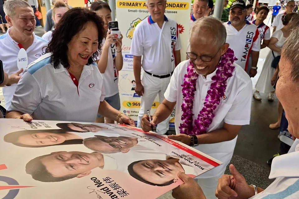 Menteri Pembangunan Sosial dan Keluarga merangkap Menteri Bertanggungjawab bagi Ehwal Masyarakat Islam, Encik Masagos Zulkifli Masagos Mohamad (dengan kalungan bunga), menandatangani poster Pilihan Raya Umum 2025 (GE2025) semasa beliau turun padang pada pagi 4 Mei, untuk mengucapkan terima kasih kepada penduduk di GRC Tampines.