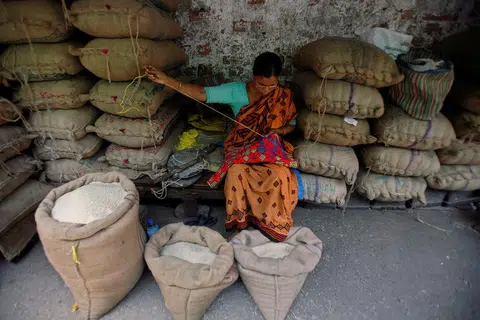 HARGA BERAS TERUS MENINGKAT: Seorang pekedai sedang menjahit di pasar borong beras di bandar Kolkata di timur India. 