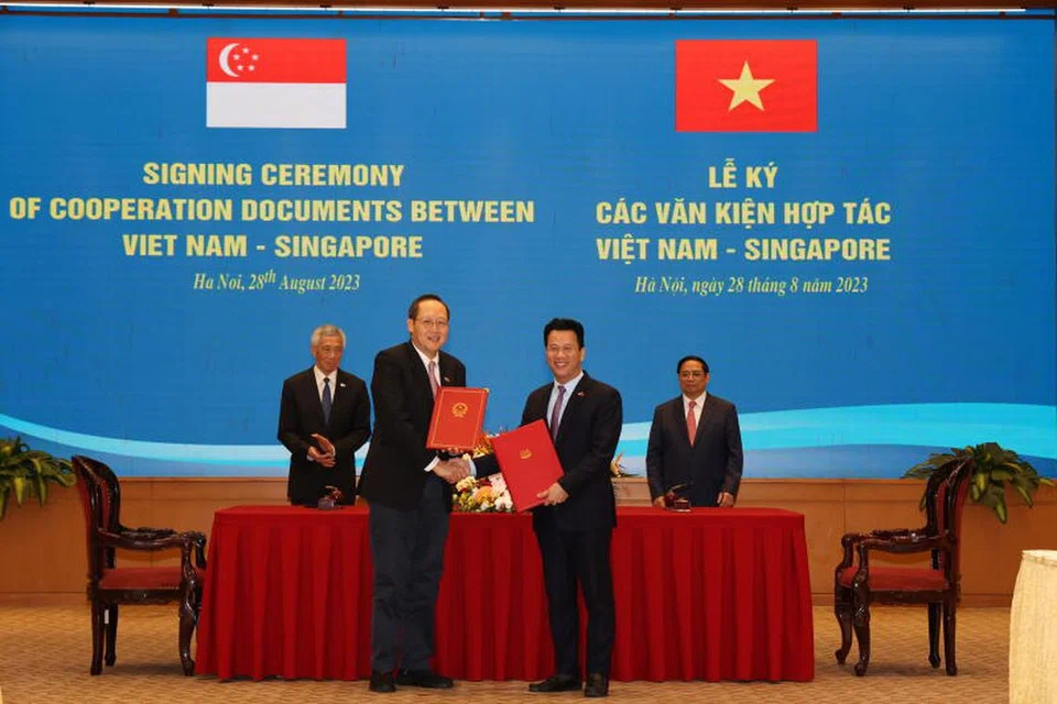 LUASKAN KERJASAMA:  Dr Tan See Leng (depan kiri) bertukar surat  dengan Menteri Sumber Asli dan Sekitaran Vietnam, Encik Dang Quoc Khanh, sambil disaksikan oleh Perdana Menteri, Encik Lee Hsien Loong (belakang kiri) dan Perdana Menteri Vietnam, Encik Pham Minch Chinch. 
