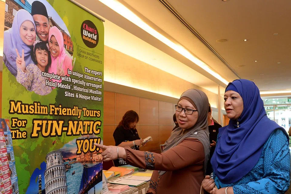 TARIK MINAT: Peserta Seminar Pelancongan Berita Harian meninjau beberapa gerai yang terdapat di auditorium Singapore Press Holdings yang menawarkan pelbagai khidmat berkaitan pelancongan. - Foto-foto TAUFIK A. KADER 