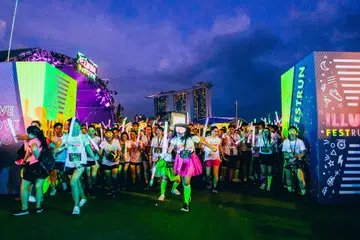 WARNA-WARNI BERLARI: Peserta Illumi Fest Run cukup bersemangat dengan pakaian bertema neon di garisan permulaan acara berlari itu di Marina Bay baru-baru ini. - Foto INFINITUS PRODUCTIONS