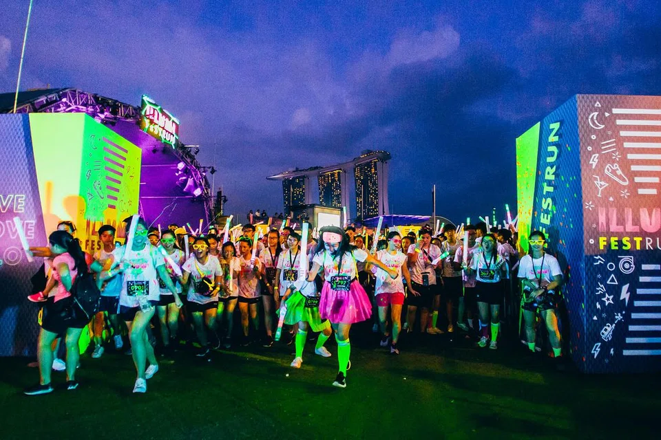 WARNA-WARNI BERLARI: Peserta Illumi Fest Run cukup bersemangat dengan pakaian bertema neon di garisan permulaan acara berlari itu di Marina Bay baru-baru ini. - Foto INFINITUS PRODUCTIONS