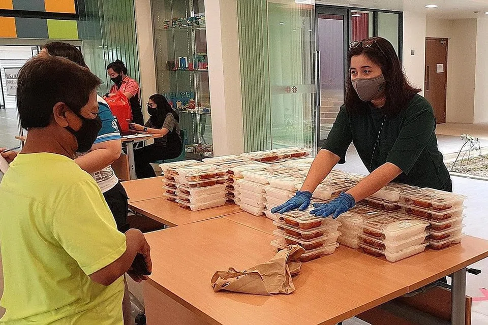 SUMBANG TENAGA: Cik Nadia (kanan), 30 tahun, meluangkan masa untuk menyumbang tenaga mengagihkan makanan di inisiatif SG Buka Puasa semasa Ramadan yang baru berlalu. - Foto ihsan NADIA AHMAD SAMDIN