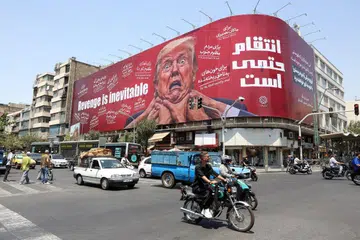 Penduduk melalui papan iklan anti-Amerika Syarikat dan Presiden Donald Trump di Teheran, Iran, pada 27 Julai 2026. Amerika Syarikat dan Iran menghentikan sementara serangan serta tindakan balas bagi memberi ruang kepada usaha diplomatik menamatkan konflik berhubung kawalan Selat Hormuz, ketika Washington memberi amaran serangan boleh disambung semula jika rundingan gagal.