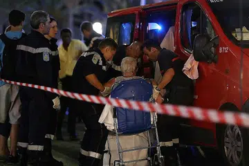 RAWATAN BAGI YANG CEDERA: Wanita yang mengalami kecederaan dalam serangan pengganasan di kota Perancis ini dipindahkan ke sebuah ambulans untuk dikejarkan ke hospital. - Foto AFP