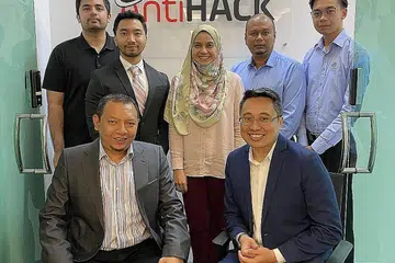 MANFAAT KEKUATAN TEKNOLOGI: Encik Khairul (kanan, duduk) bersama Pengarah Eksekutif Antah SNC Homeland Security Sdn Bhd, Dato' Shafik Rizaal Profesor Madya Hj Saaban (kiri, duduk), serta kakitangan mereka di pejabat AntiHack.me di Subang Jaya. - Foto ihsan KHAIRUL AZAM AHMAD