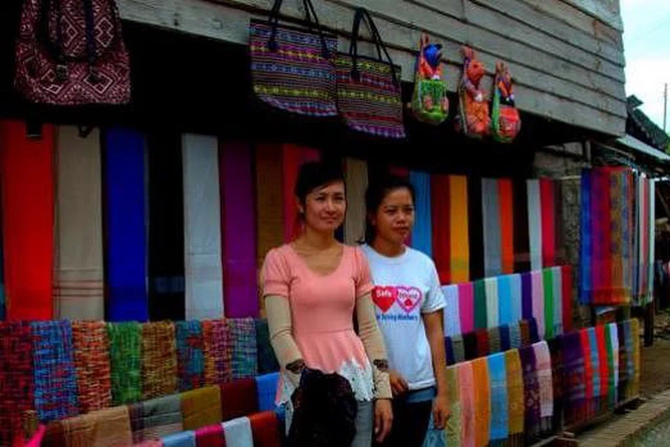 HASIL KRAF TANGAN: Dua gadis jurujual ini menjual barang tenunan di kampung Ban Xang Hai dekat Tebing Sungai Mekong. - Foto-foto MOKSIM SALEH