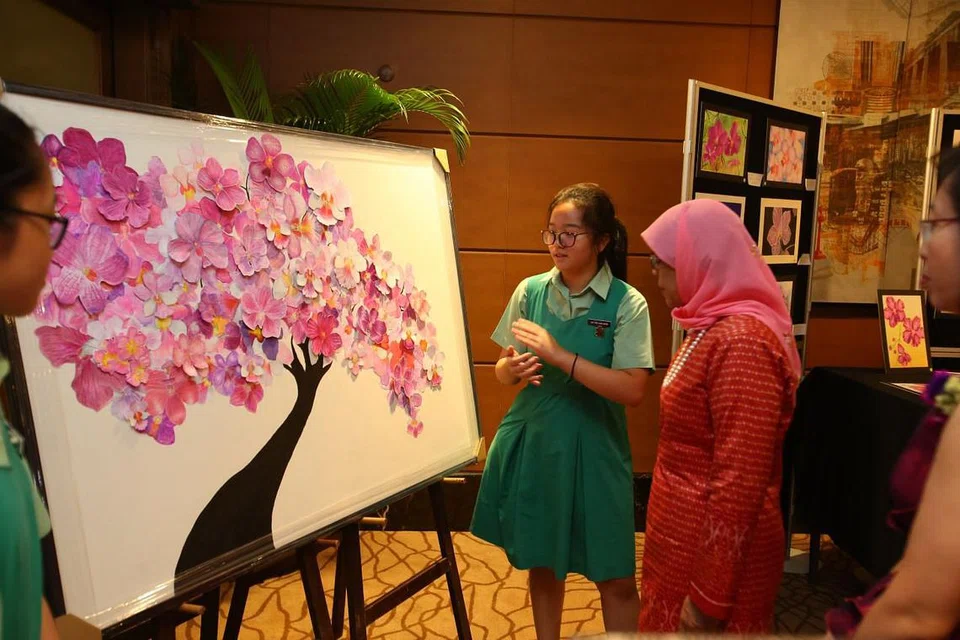 ULANG TAHUN KE-65 TKGS: Pelajar menengah dua TKGS, Wynn Lim, berkongsi dengan Presiden Halimah Yacob tentang satu karya seni yang dihasilkannya bersama rakan-rakannya.
