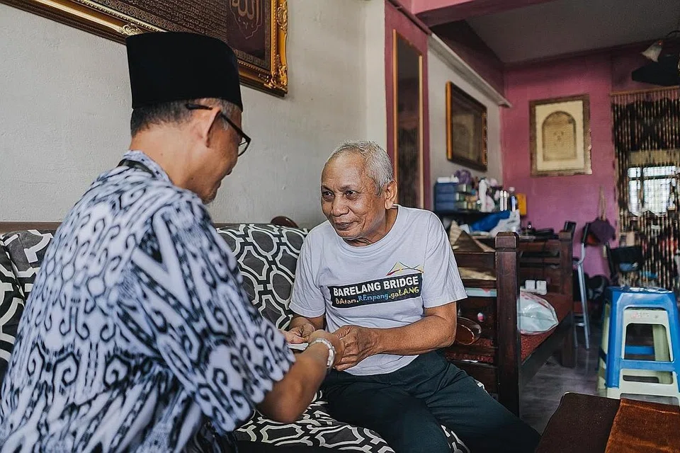 TERIMA BANTUAN: Encik Mohd Saad Atan (kanan), bersama pegawai pembangunan sosial Masjid Assyakirin. Gambar ini diambil pada 26 Februari lalu. - Foto MUIS