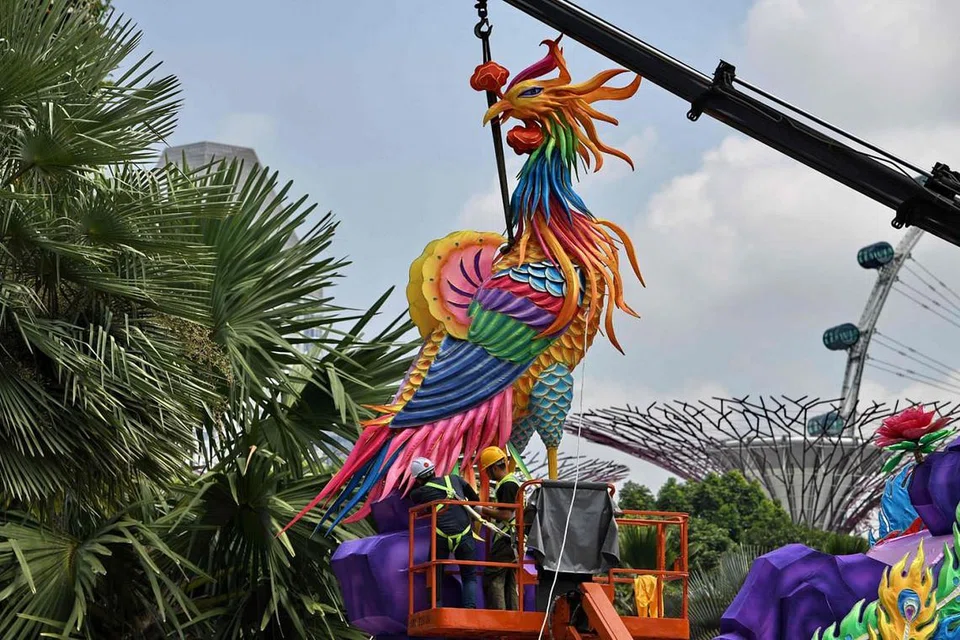 DI SEBALIK TABIR: Pekerja sedang memasang tanglung berbentuk burung phoenix dan membuat persediaan bagi festival Pertengahan Musim Gugur yang bakal berlangsung. - Foto AFP