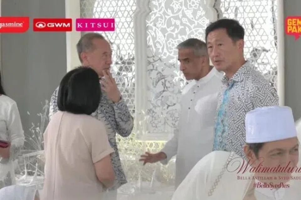 Menteri Kesihatan Singapura, Encik Ong Ye Kung (berdiri, kanan), dan mantan Menteri Ehwal Luar Singapura, Encik George Yeo (kedua dari kiri), turut menghadiri majlis akad nikah itu.