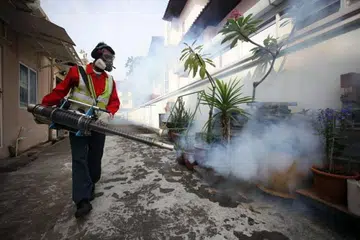 CEGAH NYAMUK MEMBIAK: Pegawai kawalan perosak menyembur asap untuk menghapuskan nyamuk di kawasan Simon Place setelah dua penduduk di situ dijangkiti virus Zika. - Foto THE STRAITS TIMES