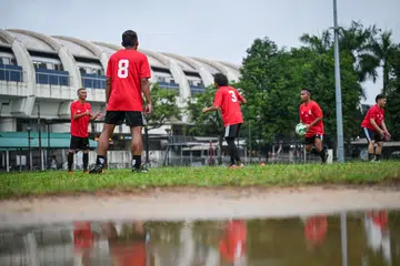 GIGIH BERLATIH: Pemain Persatuan Bola Sepak Melayu Singapura (PBMS) berlatih di padang bersebelahan Kelab Masyarakat Kampong Kembangan pada Khamis petang.