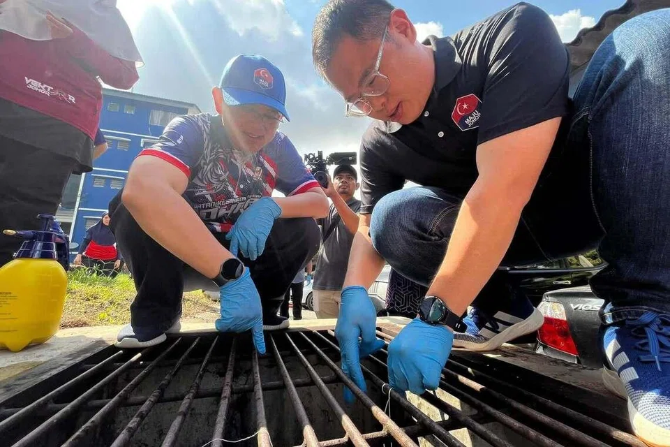Pengerusi Jawatankuasa Kesihatan dan Alam Sekitar Johor, Encik Ling Tian Soon (kanan), membuat pemantauan saliran air di sebuah penempatan awam di Tampoi, Johor Bahru.