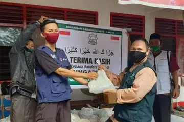 TERUS HULUR BANTUAN: Ustaz Musa Zulkifli (hadapan kanan) bersama salah seorang pegawainya, Encik Khairul Mabrur, di Indonesia menerima bantuan bagi pihak penduduk Sumbawa yang terjejas masalah banjir tahun lalu. - Foto AL-IMTAQ INTERNATIONAL & SERVICES
