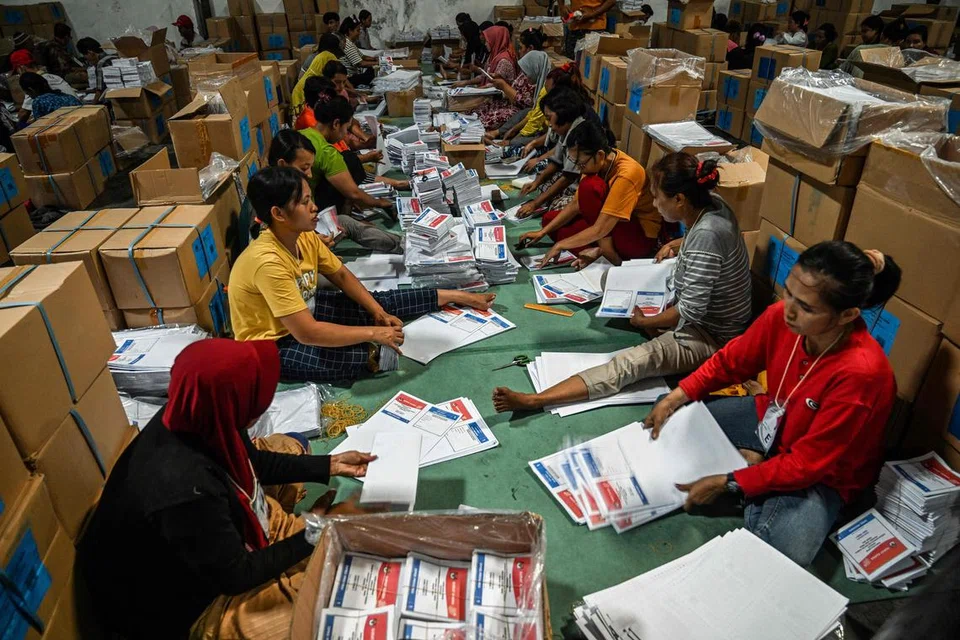 PERSEDIAAN PILIHAN RAYA: Para pegawai melipat kertas undi di Suruhanjaya Pilihan Raya Umum di Surabaya pada 21 Disember, menjelang pilihan raya umum Indonesia pada 14 Februari 2024.