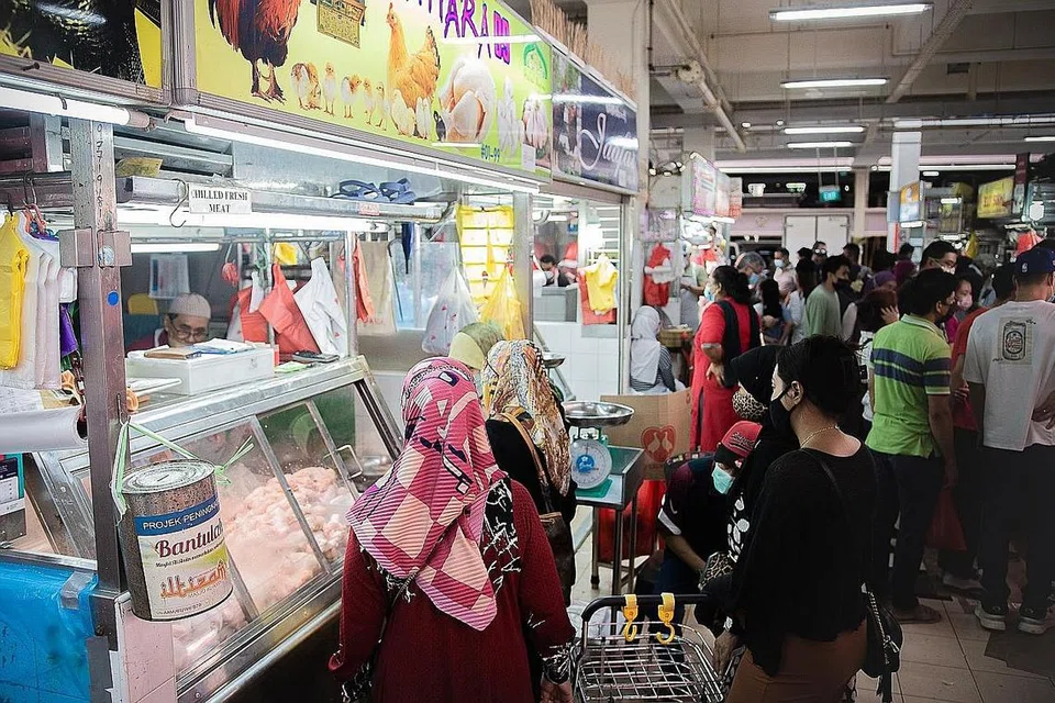 KEADAAN SEPERTI BIASA: Pelanggan kelihatan membeli ayam di bahagian daging dan ayam Pasar Geylang Serai semalam. - Foto BH oleh HARITH MUSTAFFA