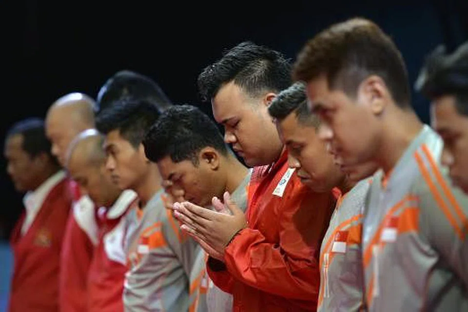 MEMPERINGATI KELUARGA TAKRAW: Pemain dan pegawai sepak takraw nasional bertafakur sebelum perlawanan dengan Indonesia.