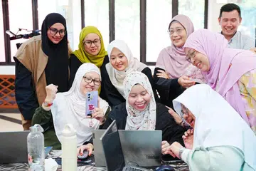 Menteri Negara (Penerangan dan Pembangunan Digital merangkap Kesihatan), Cik Rahayu Mahzam (empat dari kiri) meninjau laporan yang disiapkan salah satu kumpulan dalam bengkel ‘AI Ready’ anjuran Mendaki di Masjid Kampung Siglap pada 27 Januari.