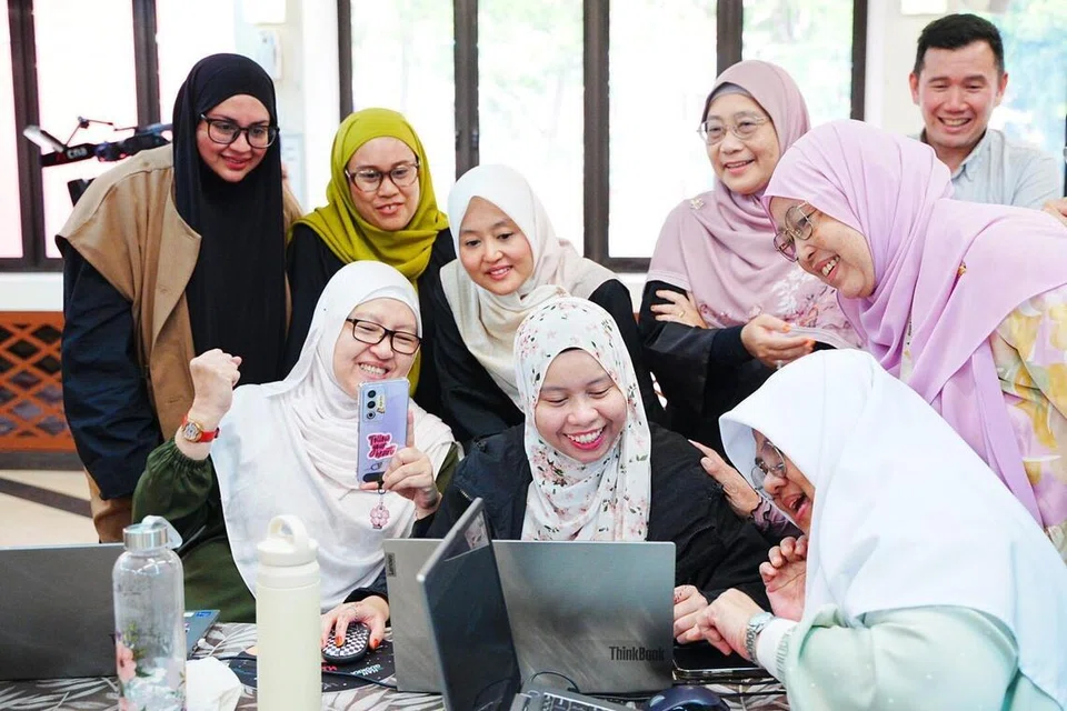 Menteri Negara (Penerangan dan Pembangunan Digital merangkap Kesihatan), Cik Rahayu Mahzam (empat dari kiri) meninjau laporan yang disiapkan salah satu kumpulan dalam bengkel ‘AI Ready’ anjuran Mendaki di Masjid Kampung Siglap pada 27 Januari.