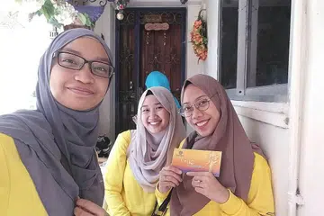 KIRIM BANTUAN: Peserta Project Joy (dari kiri) Cik Nur Adila Mohamad Yusof, Cik Fatin Farzana Miswan dan Cik Nurul Sakina Ismail membantu mengirimkan bekalan dari rumah ke rumah semasa menyertai projek kemasyarakatan itu. - Foto ihsan NURUL SAKINA ISMAIL