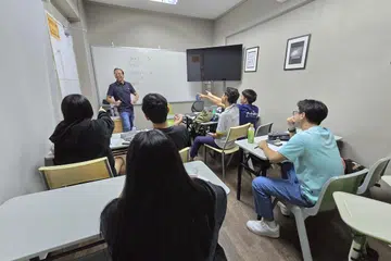 Encik Mohamed Fathurahman Mohamed Nasir (berdiri) cuba menerapkan persekitaran kondusif dalam mengendalikan kelas dan menekankan peri pentingnya penglibatan ibu bapa dalam bersikap terbuka untuk mendengar dalam usaha memahami anak mereka. 