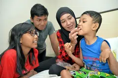 TIDAK PUTUS ASA: Bagi Cik Kamisah kebahagiaan anak-anaknya - (dari kiri) Nadra, Firdaus dan Putra - terus memberi semangat untuk bekerja keras demi menyara kehidupan keluarganya. - Foto M.O. SALLEH