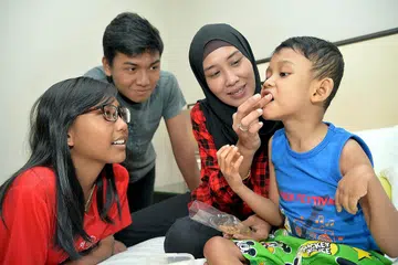 TIDAK PUTUS ASA: Bagi Cik Kamisah kebahagiaan anak-anaknya - (dari kiri) Nadra, Firdaus dan Putra - terus memberi semangat untuk bekerja keras demi menyara kehidupan keluarganya. - Foto M.O. SALLEH