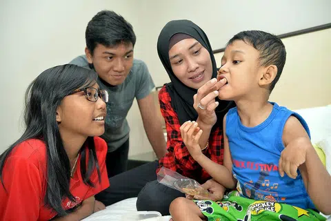 TIDAK PUTUS ASA: Bagi Cik Kamisah kebahagiaan anak-anaknya - (dari kiri) Nadra, Firdaus dan Putra - terus memberi semangat untuk bekerja keras demi menyara kehidupan keluarganya. - Foto M.O. SALLEH