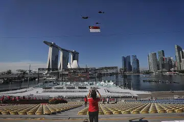 DIRGAHAYU SINGAPURA: Istiadat perbarisan Hari Kebangsaan diadakan dalam skala yang kecil dengan penyertaan 600 peserta berseragam dan 100 penonton yang hadir di platform terapung Marina Bay pagi semalam, di tengah-tengah sekatan ketat Fasa Dua (Kewaspadaan Dipertingkat). - Foto BH oleh KELVIN LIM