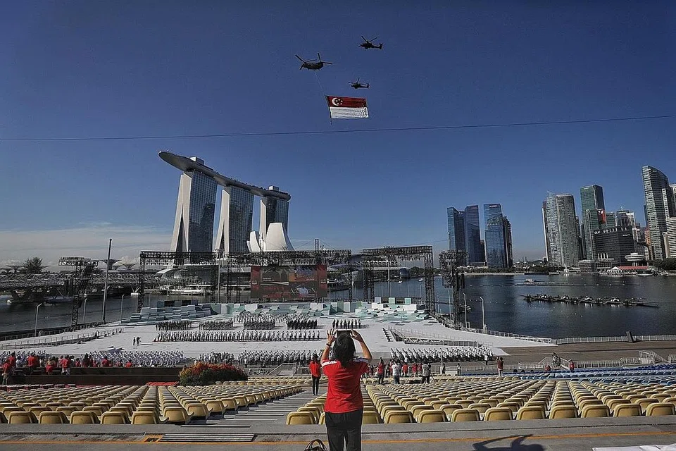 DIRGAHAYU SINGAPURA: Istiadat perbarisan Hari Kebangsaan diadakan dalam skala yang kecil dengan penyertaan 600 peserta berseragam dan 100 penonton yang hadir di platform terapung Marina Bay pagi semalam, di tengah-tengah sekatan ketat Fasa Dua (Kewaspadaan Dipertingkat). - Foto BH oleh KELVIN LIM