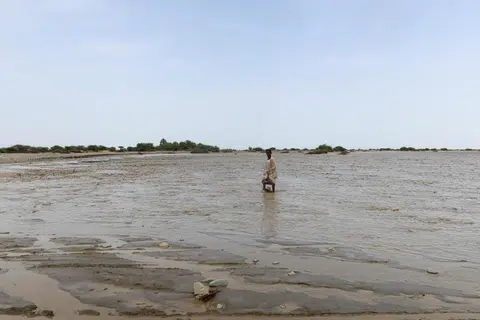 Seorang penduduk dilihat mengharungi banjir yang melanda di Pelabuhan Sudan pada 26 Ogos.