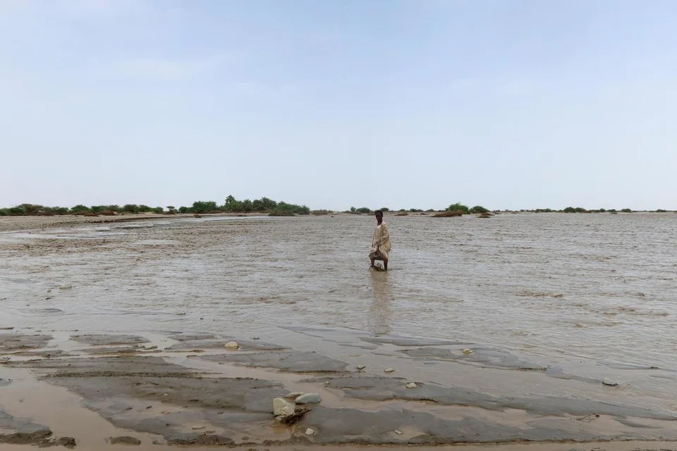 Seorang penduduk dilihat mengharungi banjir yang melanda di Pelabuhan Sudan pada 26 Ogos.