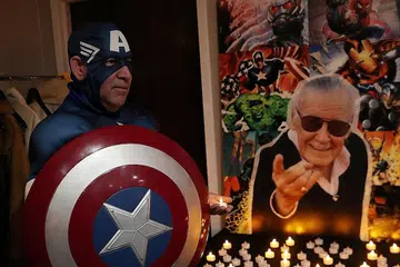 PEMERGIAN DIKENANG: Ikon dunia komik Stan Lee, yang meninggal dunia ketika berusia 95 tahun Isnin lalu (berkaca mata hitam), dikenang ramai, misalnya peminat ini yang menggayakan watak adiwira Lee Captain America di Stony Brook, New York, kelmarin. - Foto REUTERS