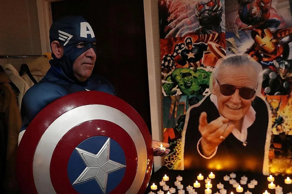 PEMERGIAN DIKENANG: Ikon dunia komik Stan Lee, yang meninggal dunia ketika berusia 95 tahun Isnin lalu (berkaca mata hitam), dikenang ramai, misalnya peminat ini yang menggayakan watak adiwira Lee Captain America di Stony Brook, New York, kelmarin. - Foto REUTERS