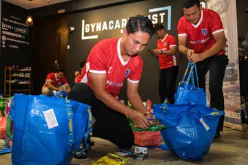 Bekas kapten pasukan bola sepak Singapura, Shahril Ishak (depan), bersama beberapa lagi bekas pemain kebangsaan menyiapkan habuan Hari Raya untuk diagih kepada penduduk Jalan Kukoh pada 22 Mac. 