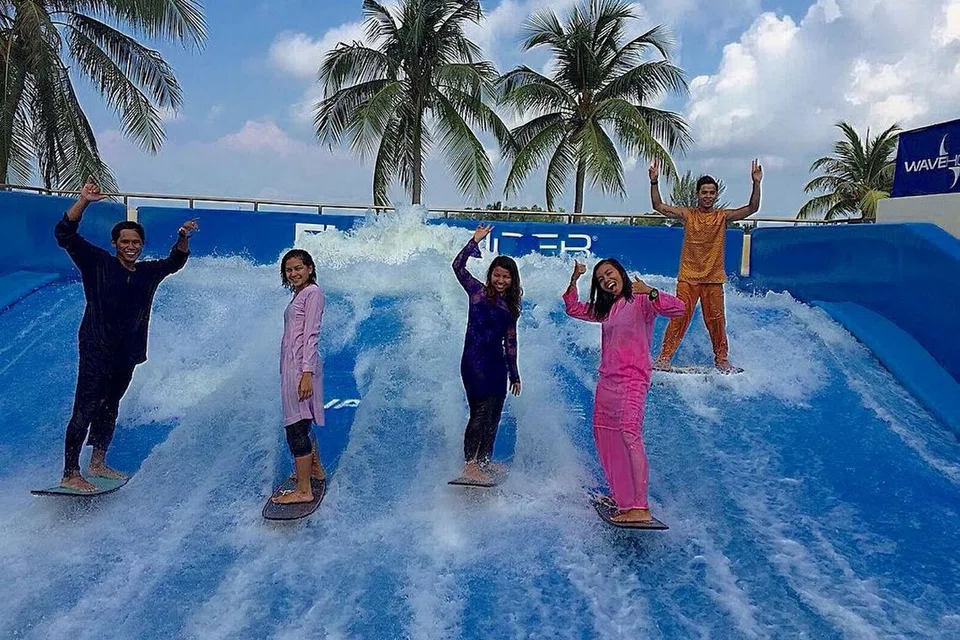 KELUARGA 'FLOWBOARD': (Dari kiri) Encik Hisham Jamal, Cik Deena Mumtaz Adam, Cik Ili Lim, Cik Amalina Aidal dan Encik Faris Samad sehati sejiwa mengenakan baju kurung Melayu ketika beraksi sempena Hari Raya tahun lalu di Wavehouse Sentosa. - Foto ihsan SHAM JAMAL, JEABJA DERKAR dan MOHAMAD ALI IBRAHIM