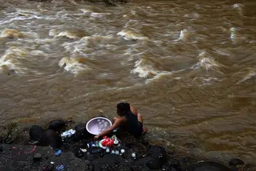 BENCANA ALAM: Seorang wanita membasuh pinggan mangkuk di tebing Sungai Chilama di Pelabuhan La Libertad di salah sebuah kawasan paling teruk terjejas akibat Ribut Tropika Amanda, di La Libertad, El Salvador, semalam. Ribut Amanda bukan hanya menyebabkan kemusnahan teruk tetapi meragut nyawa sedang ia membadai kawasan utara Amerika Tengah, mengakibatkan 18 orang terbunuh dan kemusnahan rumah dan jalan raya akibat puting beliung terburuk yang dihadapi negara itu. 