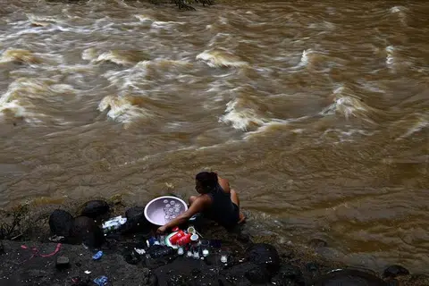 BENCANA ALAM: Seorang wanita membasuh pinggan mangkuk di tebing Sungai Chilama di Pelabuhan La Libertad di salah sebuah kawasan paling teruk terjejas akibat Ribut Tropika Amanda, di La Libertad, El Salvador, semalam. Ribut Amanda bukan hanya menyebabkan kemusnahan teruk tetapi meragut nyawa sedang ia membadai kawasan utara Amerika Tengah, mengakibatkan 18 orang terbunuh dan kemusnahan rumah dan jalan raya akibat puting beliung terburuk yang dihadapi negara itu. 